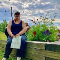 woman sitting next to garden